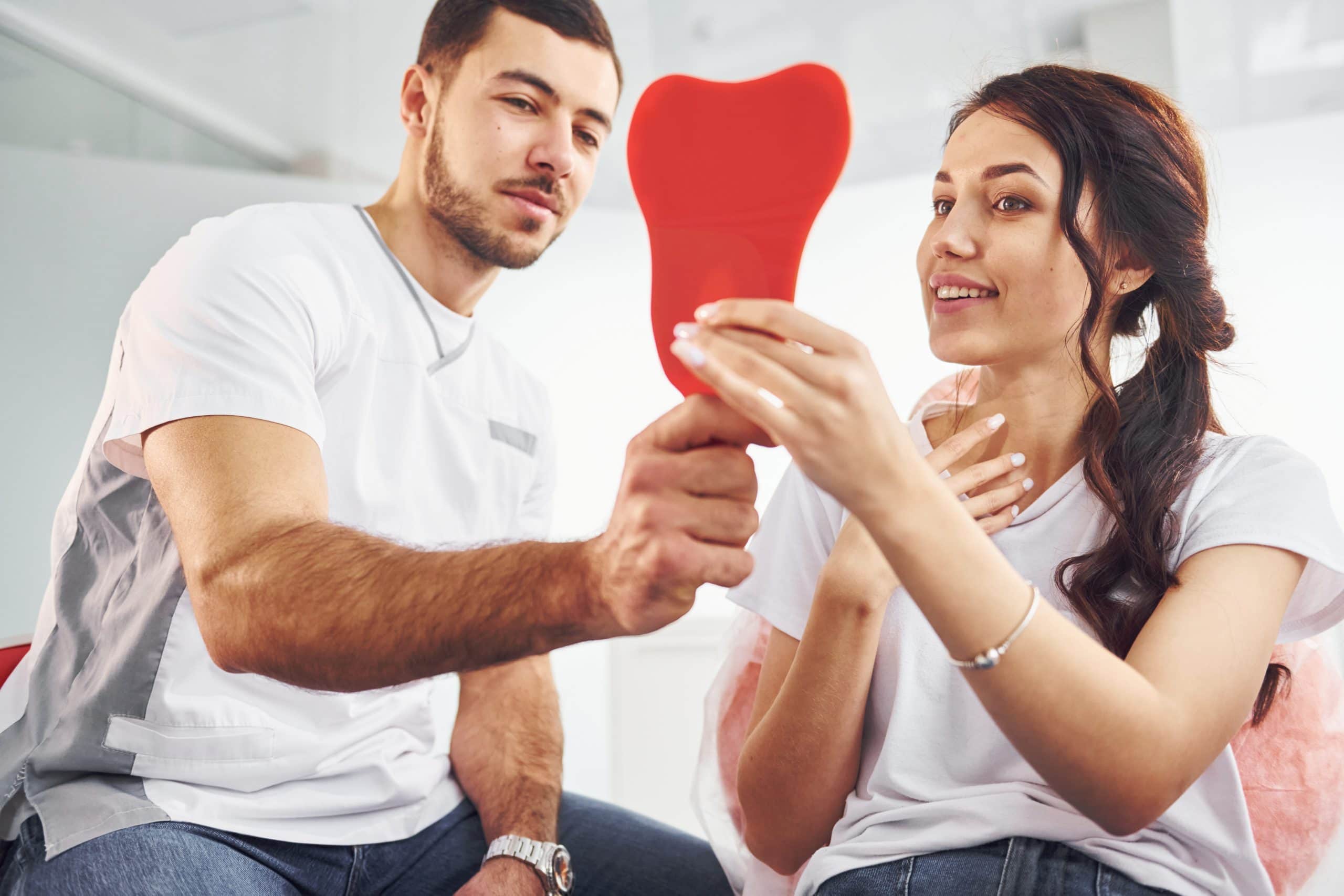 looks into the mirror. woman visiting dentist in clinic. conception of stomatology